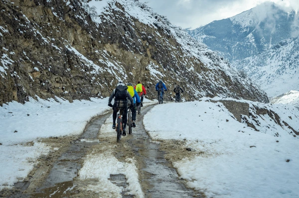bicyclists biking on snowy road