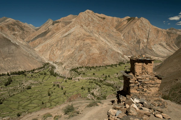 Panoramic view of Shimengaon’s green rice fields and rugged mountains, seen from a high vantage point along the Upper Dolpo Trek in Nepal.